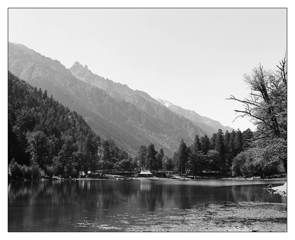 A mountain ridge reflected in the still water of Kara-Kel Lake
